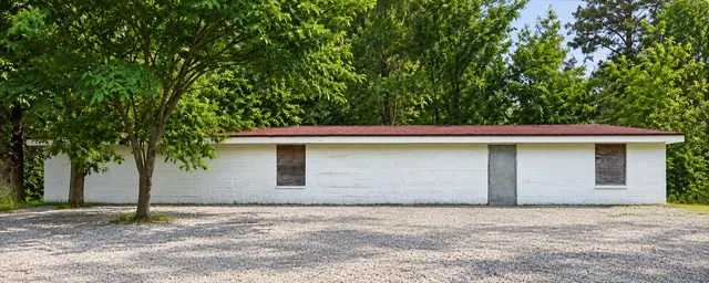 Restored visualization of the original white church building with its gravel parking area